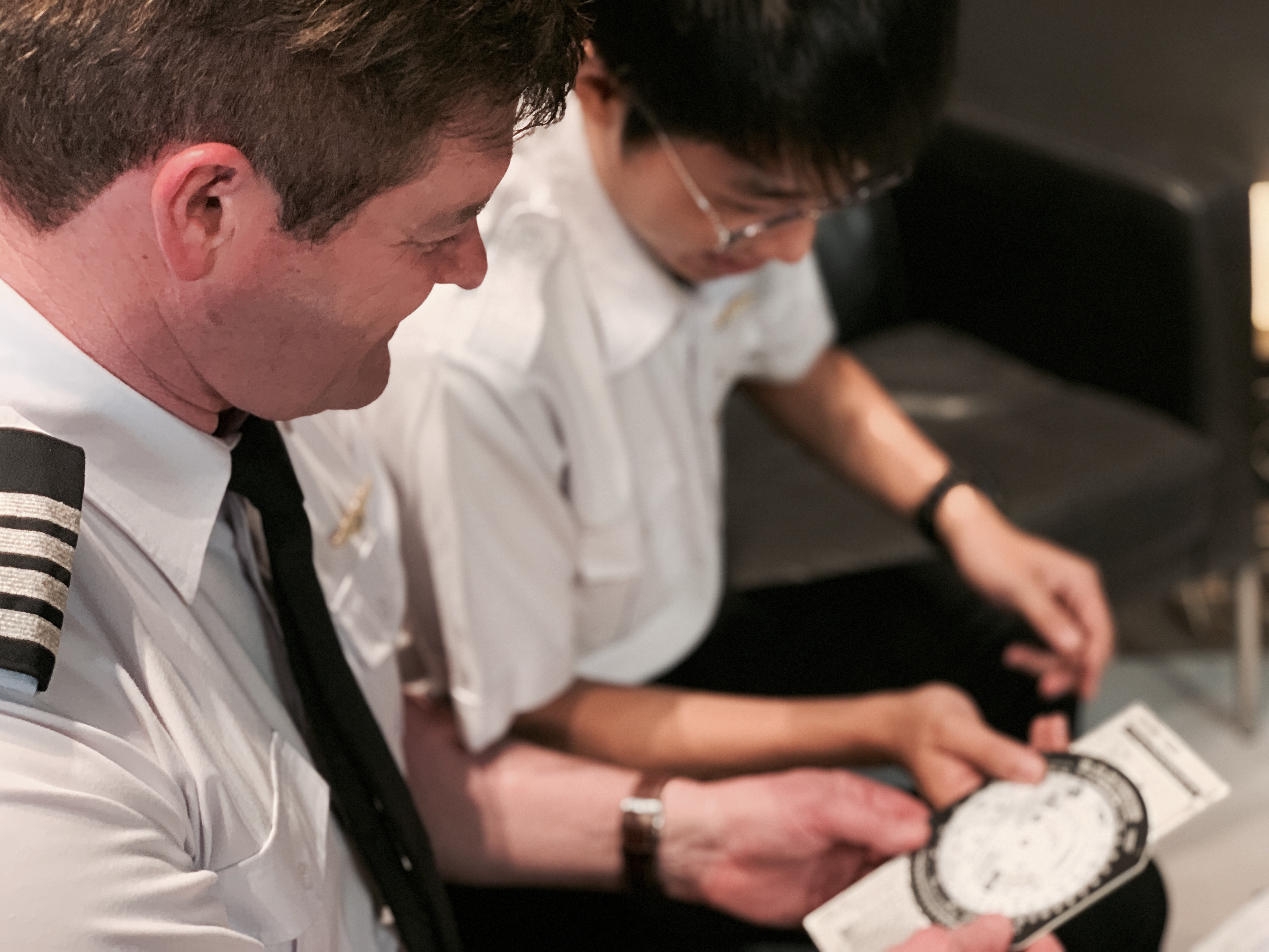 Flight instructor teaching student pilot how to use an aviation flight computer during Recreational Pilot Certificate training in Australia.